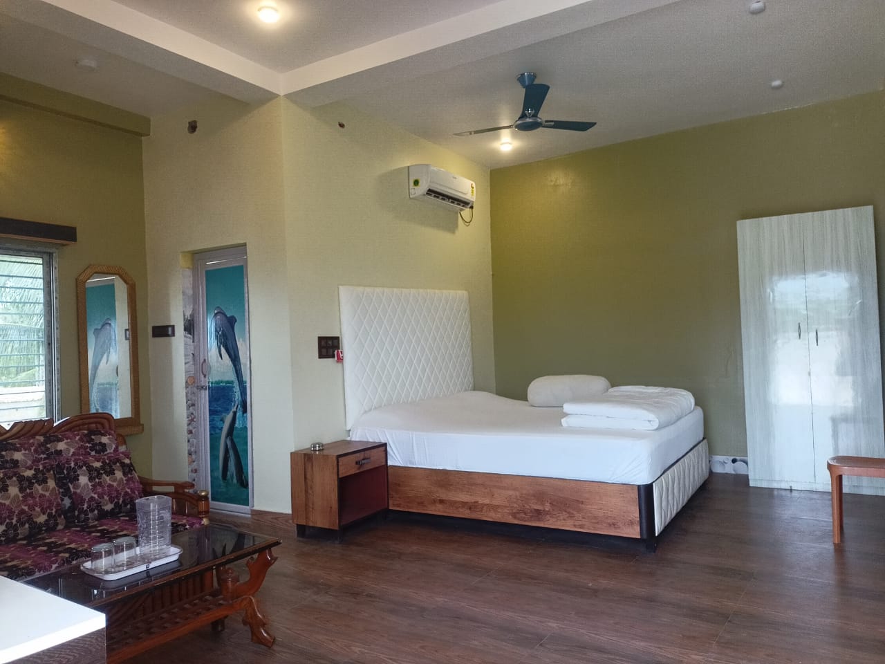 Spacious air-conditioned guest room with king bed, sofa seating and attached bathroom