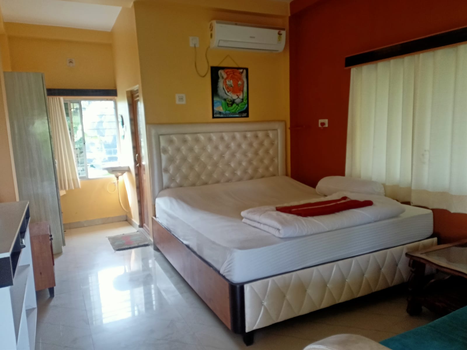 Double-bed AC room with tufted headboard, wardrobe and balcony access