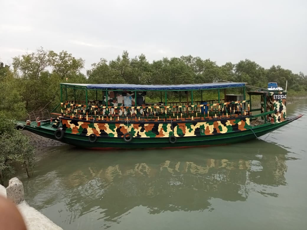 Our camouflage-painted Sundarban safari boat moored beside the mangroves